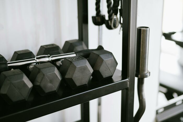 Set of hexagonal dumbbells on a rack in a gym showing then vs now scenarios for fitness equipment comparison.