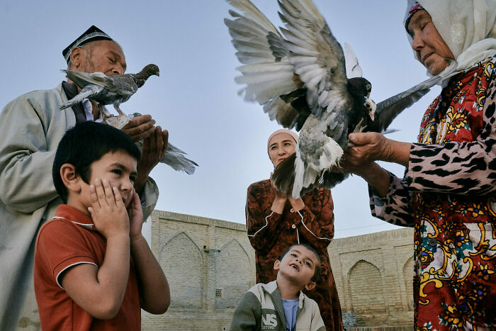 Children and elders releasing pigeons outdoors, capturing unforgettable street photos that turn everyday life into art.