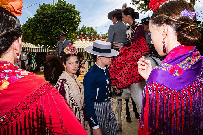 Colorful street photo of people in traditional Spanish attire capturing unforgettable moments of everyday life as art.