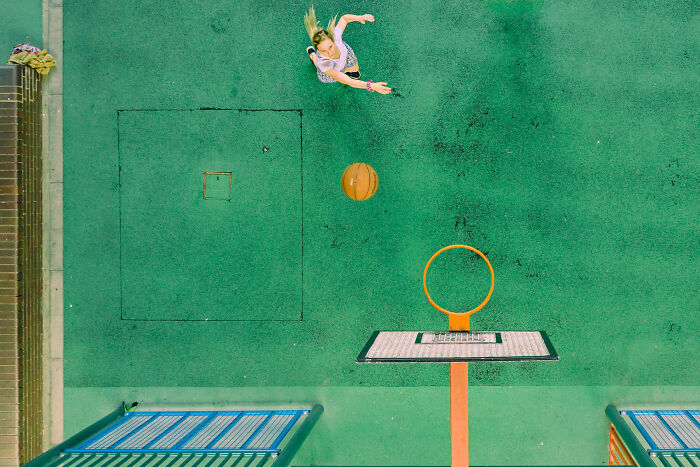 Young woman shooting a basketball on an outdoor court, capturing stunning moments of nature, people, and life.