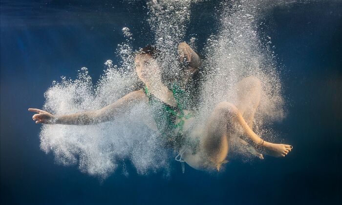 Person underwater surrounded by bubbles, capturing stunning moments of life and nature in an aquatic setting.