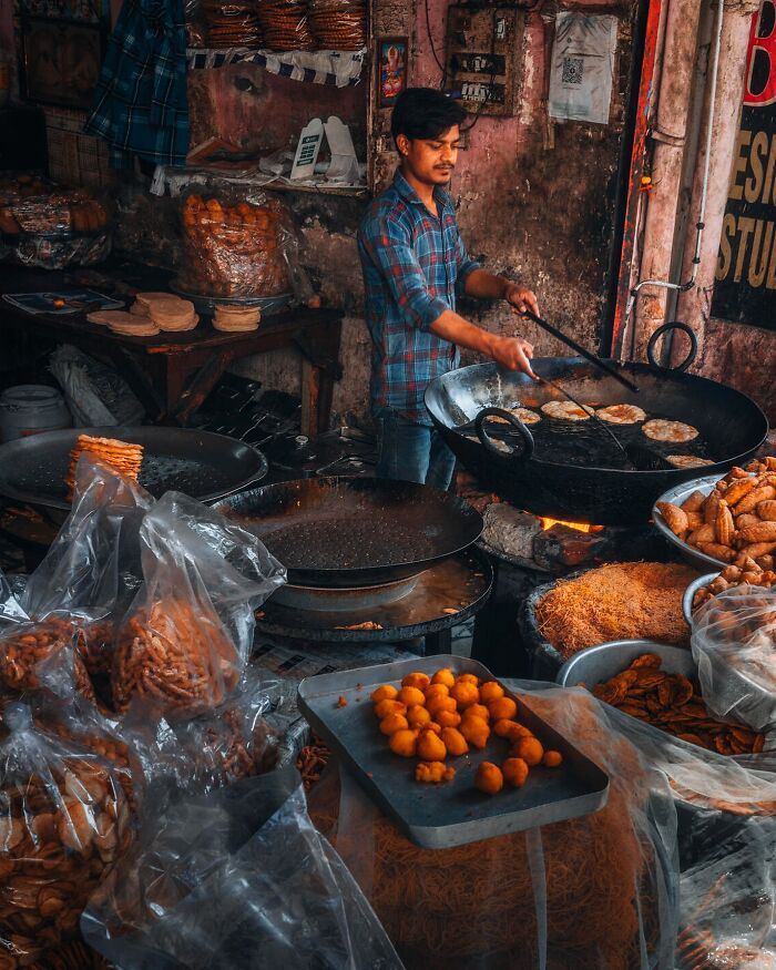 Man cooking traditional snacks in a rustic kitchen, capturing people and life around the world in an authentic setting.