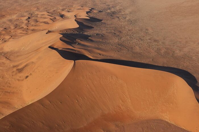 Aerial view of vast sand dunes showcasing stunning nature and life in a remote desert landscape around the world.