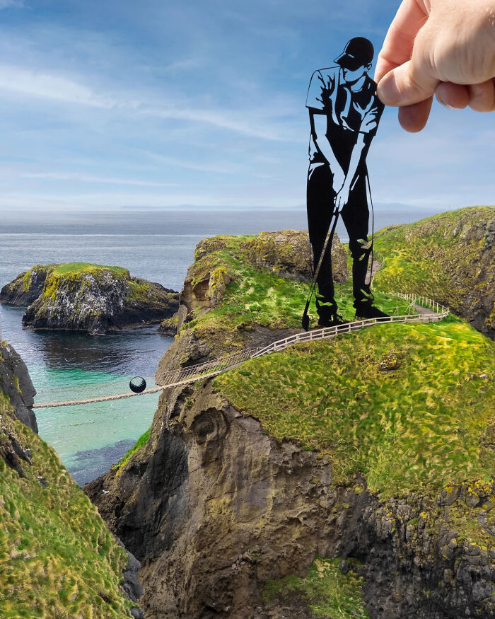 Hand holding paper cutout of a golfer creating surprising scenes on a cliffside landscape by the ocean.