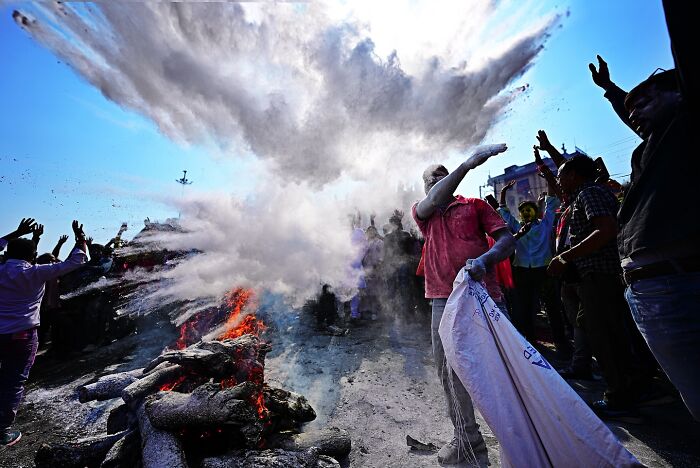 People celebrating with colorful powder and fire during a vibrant event in India bursting with color and life
