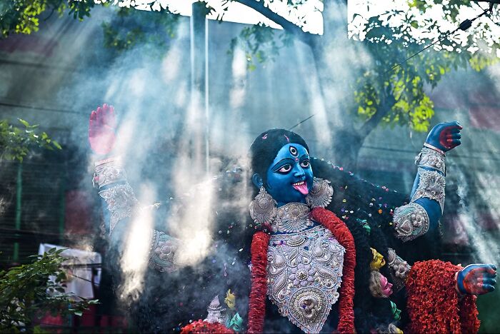 Statue of Hindu goddess Kali with vibrant blue skin and garlands, captured in vivid photos of India full of color and life.