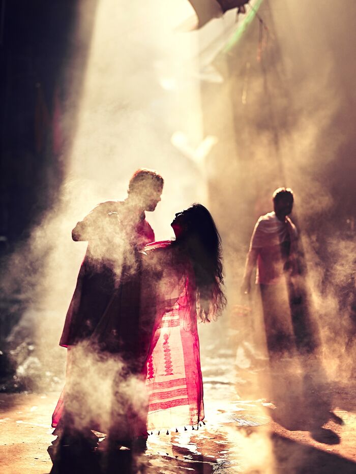 Couple immersed in vibrant smoke and light on an Indian street, showcasing vivid colors and life in India photography.