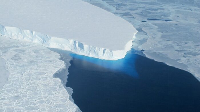 Arctic ice melting into ocean, illustrating aspects of modern life frighteningly close to breaking down.