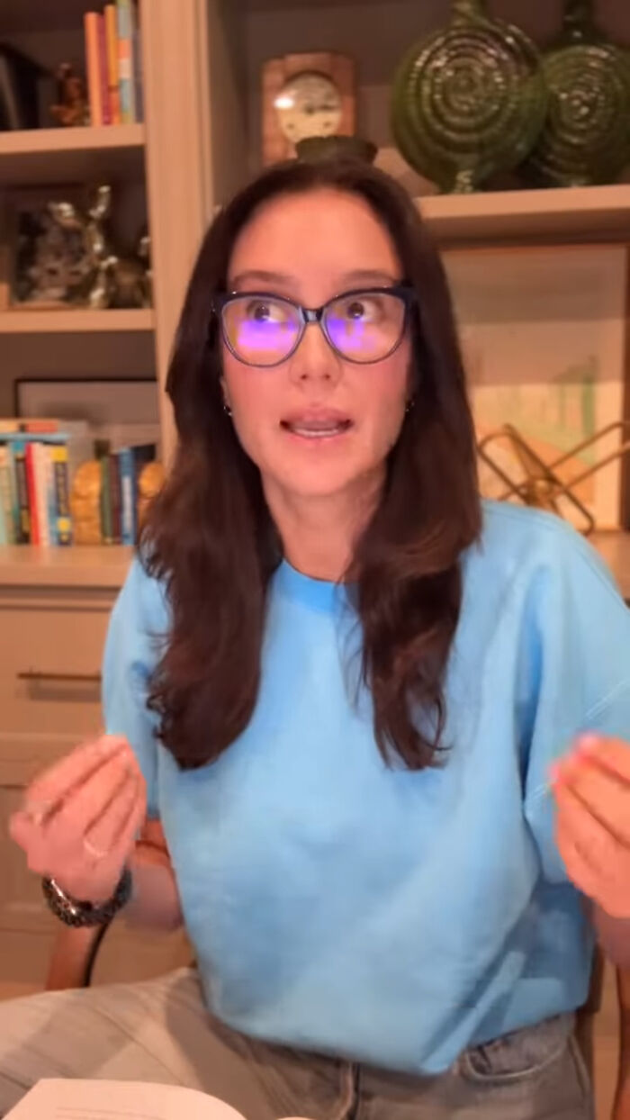 Bruce Willis's wife wearing glasses and blue shirt sharing an update on their separate living during his dementia battle.