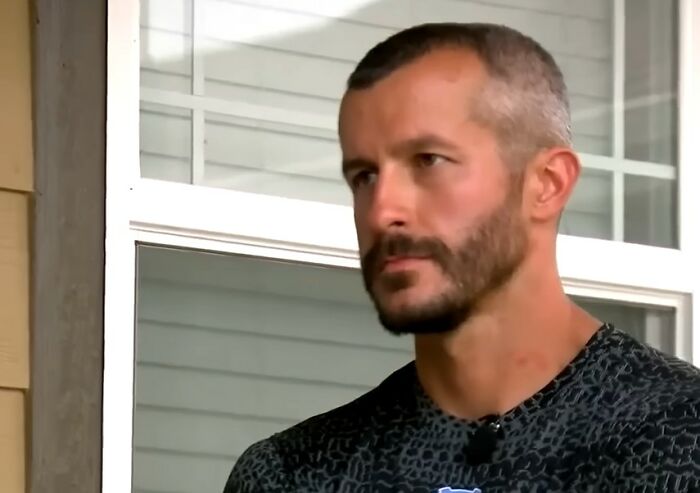 Man with short hair and beard sitting outdoors near a window, featured in videos that gain meaning with more context. - 28