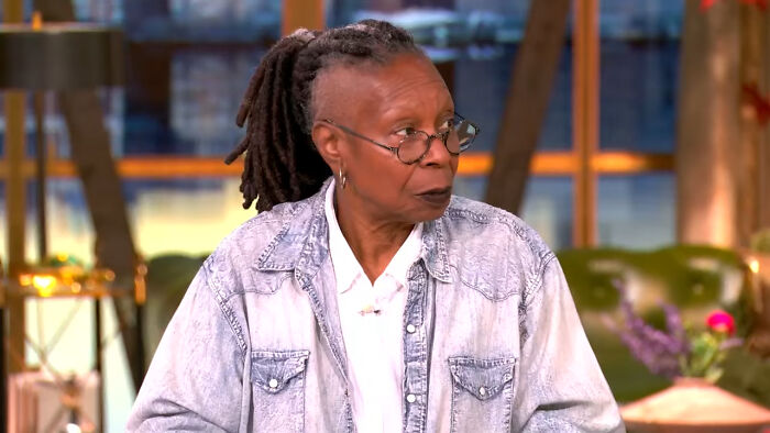 Person with glasses and dreadlocks speaking indoors, illustrating celebrities showing entitlement about work and life.