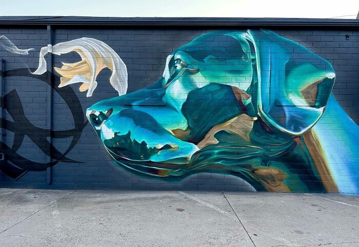 Mural by Alexander Vizsla Bacon featuring a realistic blue dog blending graffiti art with abstraction on a brick wall.