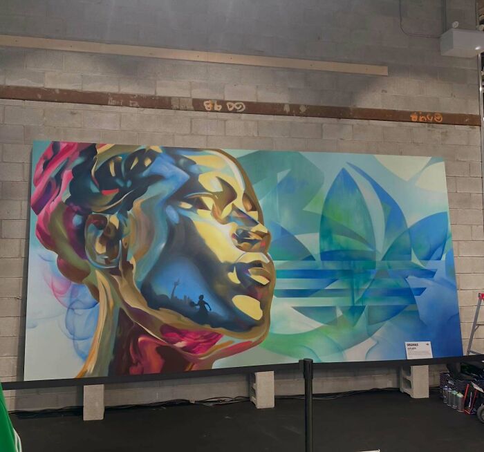 Colorful mural blending graffiti, realism, and abstraction depicting a woman's face with vibrant blues, greens, and gold tones.