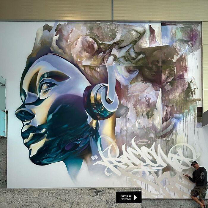 Large mural blending graffiti, realism, and abstraction featuring a stylized face with headphones by Alexander Vizsla Bacon.