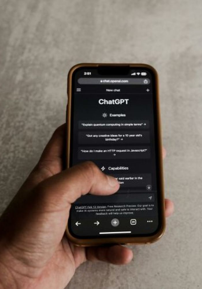 Hand holding smartphone displaying ChatGPT interface on screen, related to influencer blaming AI for missed flight.