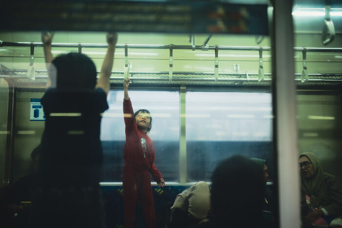Child reaching up inside a train captured by a photographer turning ordinary moments into poetic cinematic images.