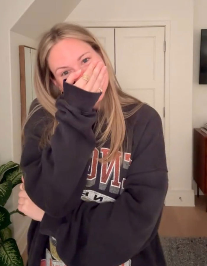 Woman covering her mouth with hand, reacting to extreme diarrhea on plane causing emergency landing and flight cancellation.