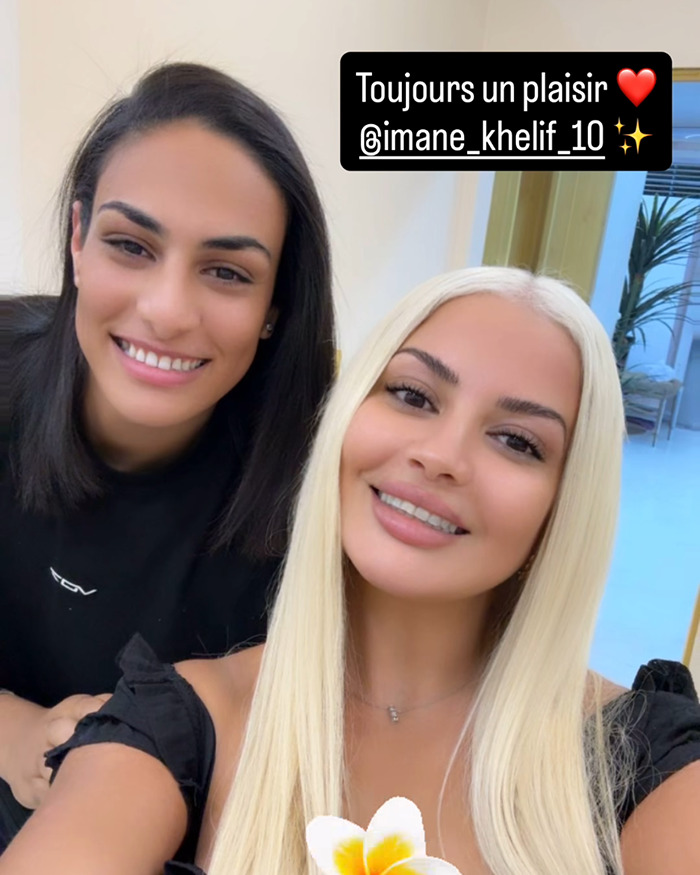 Imane Khelif with dark hair and dramatic blonde makeover smiling with friend indoors after Paris Olympics controversy.