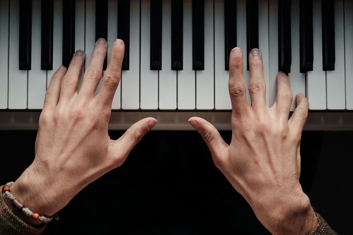 Hands playing piano keys illustrating the wealth gap perspective through creative storytelling and visual contrast.