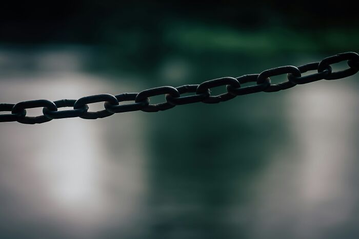 Close-up of a dark metal chain against a blurred background representing disturbing facts people wish they didn’t know.