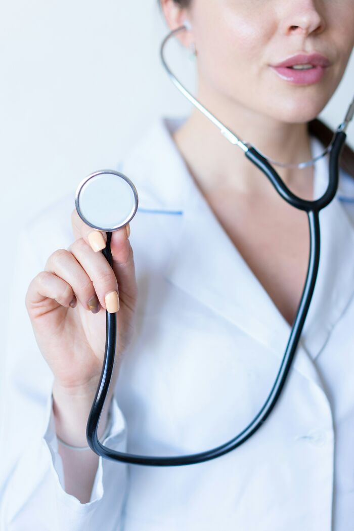 Female doctor in a white coat holding a stethoscope, symbolizing disturbing facts about health people shared.