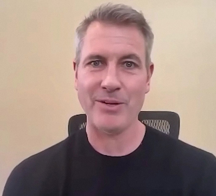 Chris Martin speaking in a video call, addressing the cheating scandal controversy in a casual indoor setting.