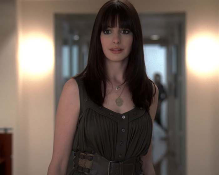 Anne Hathaway on set with dark hair and sleeveless dress, related to viral video of heel breaking and falling off stairs.
