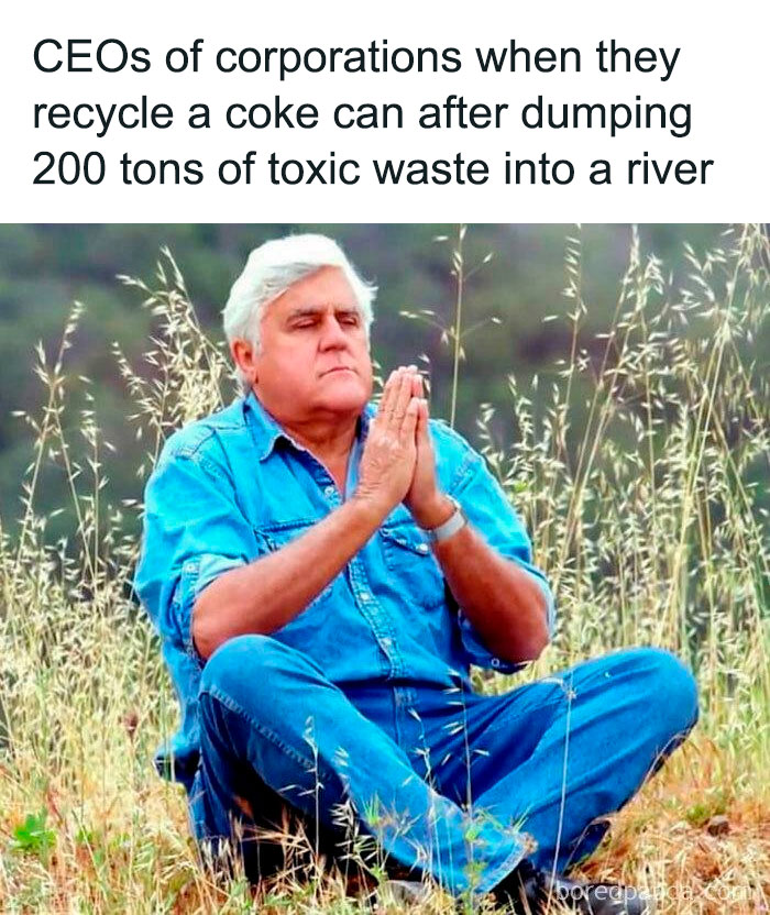 Man in blue denim sitting in grass with hands in prayer pose, symbolizing consumerism's environmental impact and corporate hypocrisy.