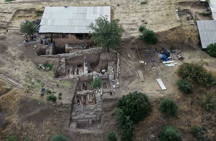 Aerial view of ancient Lydian palace ruins under excavation in Western T&uuml;rkiye with archaeologists at the site.