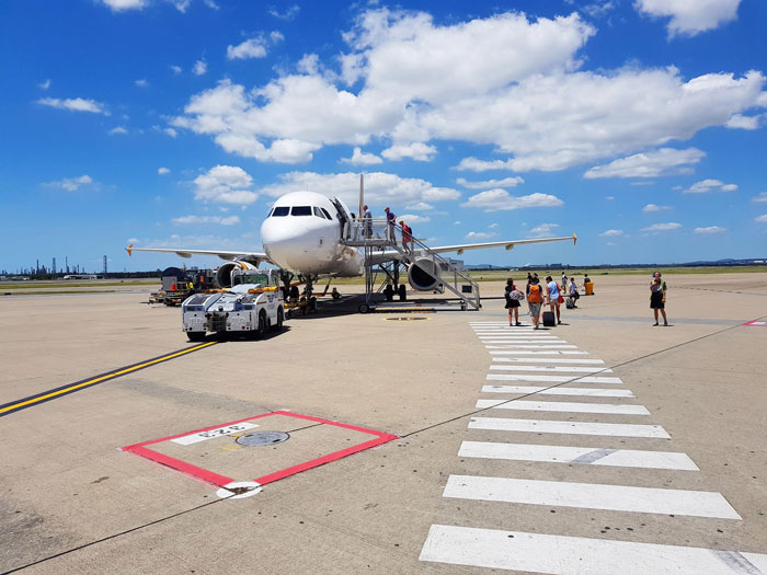 Passengers boarding a plane under a bright blue sky, highlighting a lady wanting the aisle seat on board. Passengers boarding a plane under a bright blue sky, highlighting a lady wanting the aisle seat on board.