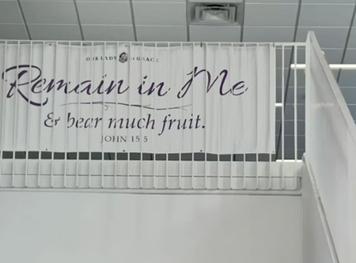Banner with religious text reading Remain in Me, poorly aligned and difficult to read, showing design fails in placement.