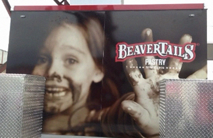 Mismatched design fail on a BeaverTails pastry truck with a child’s face and dirty hand creating a confusing visual effect.