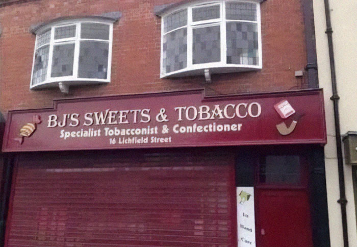 Storefront sign for sweets and tobacco with confusing design creating an obvious design fail on a busy street.