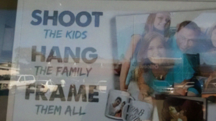 Design fail with confusing sign saying shoot the kids hang the family frame them all, showing poor design choices.