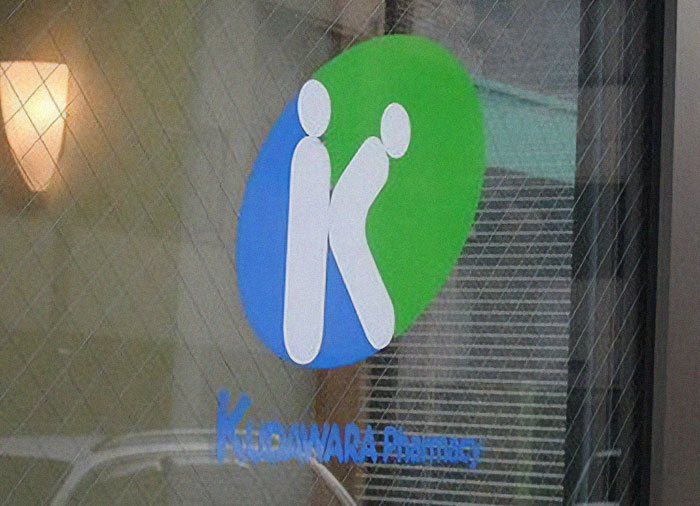 Logo design fail with distorted letters on a glass door, showing a clear example of design fails approved in public spaces.