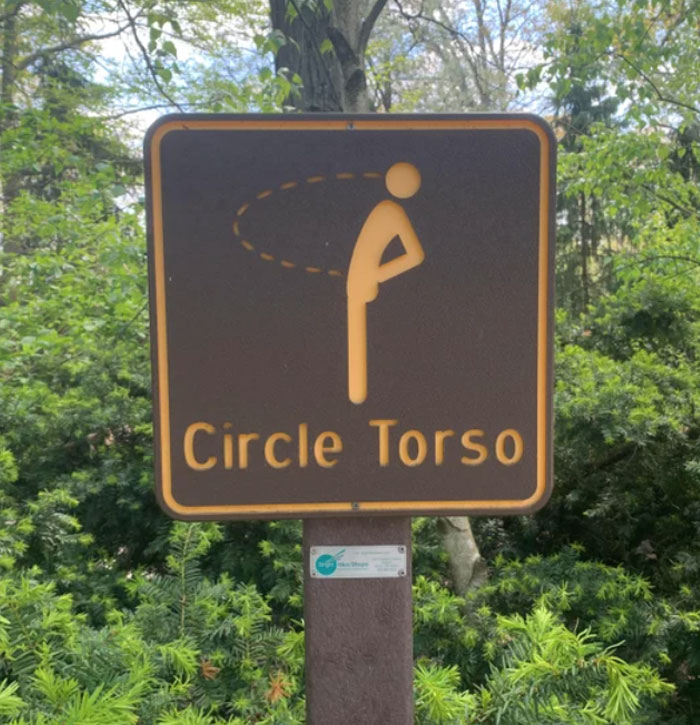 Sign with a poorly designed figure labeled Circle Torso, illustrating a clear design fail in a natural outdoor setting.