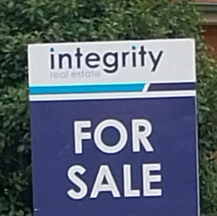 Real estate sign with confusing design, showing integrity but making the sale message unclear in a design fail example.