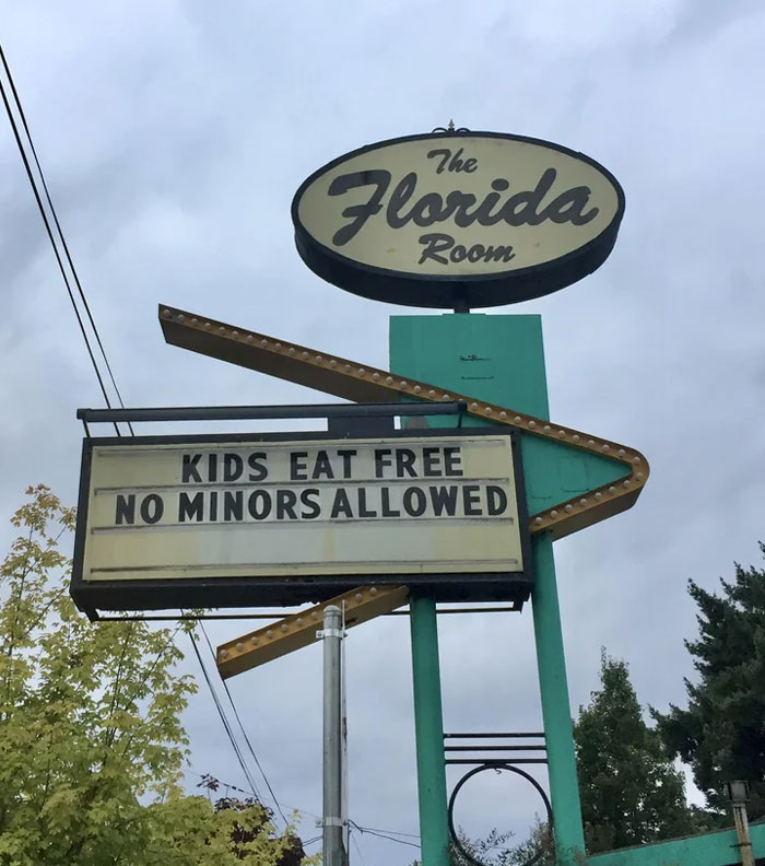 Confusing sign design fail stating kids eat free but no minors are allowed on a restaurant sign.