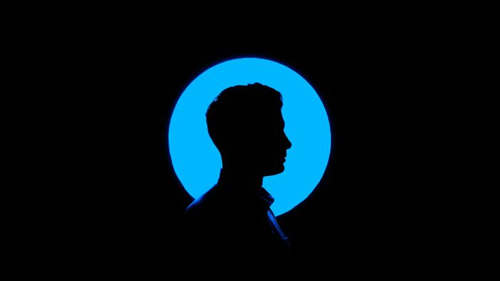Silhouette of a person against a glowing blue circle, evoking eerie and creepy vibes related to imaginary friends.