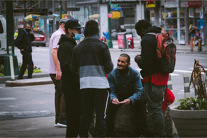 Group of people gathering and talking outdoors in an urban setting illustrating street smart tips and tricks.