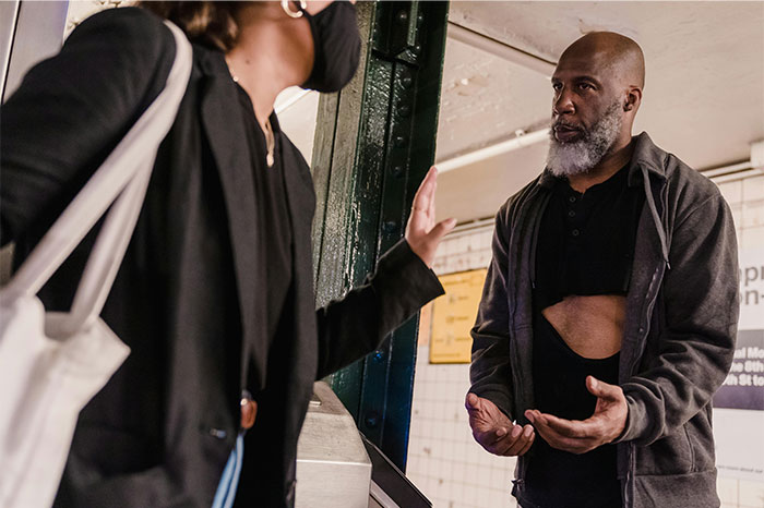 Two people interacting in a subway station demonstrating street smart communication and situational awareness skills.