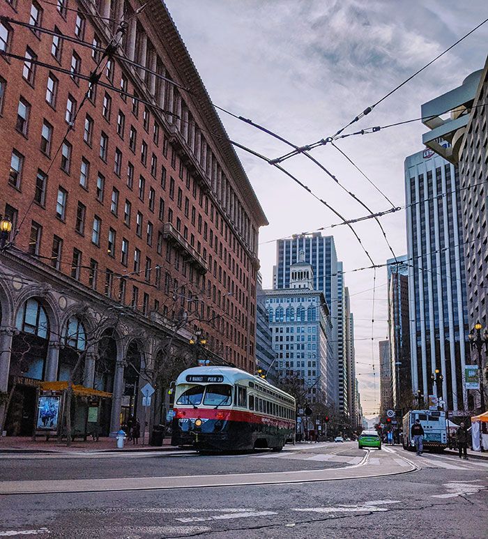 Streetcar on urban city street lined with tall buildings, illustrating reverse culture shocks experienced by Americans moving back home.