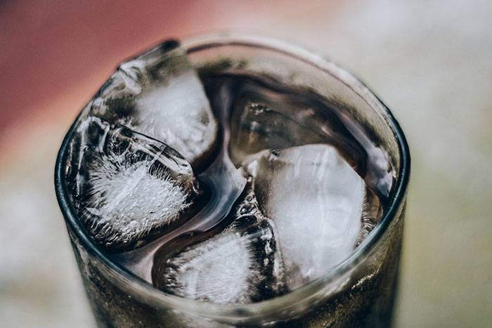 Close-up of a cold beverage with ice cubes illustrating comfort amid reverse culture shocks experienced by Americans returning home.