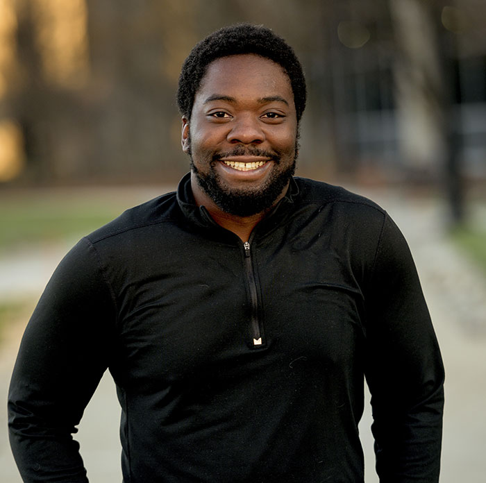 Smiling man outdoors in casual black top, representing reverse culture shocks experienced by Americans moving back home.