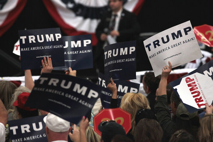 Crowd holding Trump signs at a political rally, an unexpected discovery in the biggest world event context.