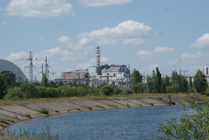 Abandoned industrial site near water with clear sky, representing one of the biggest world unexpected discoveries in history.