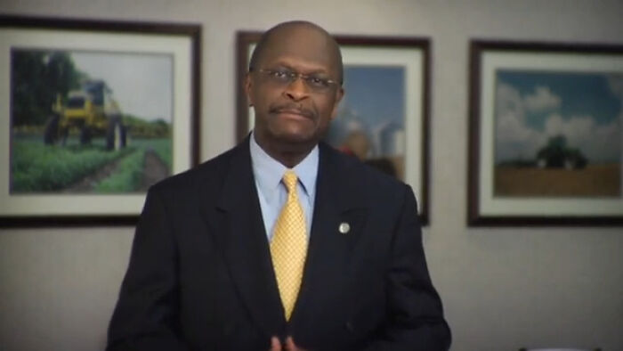 Man in a suit and yellow tie speaking in an office with framed pictures, related to biggest world unexpected discoveries topic.