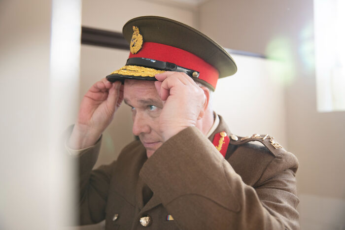 Man in a vintage military uniform adjusting his hat, symbolizing unexpected discoveries in the biggest world history context.