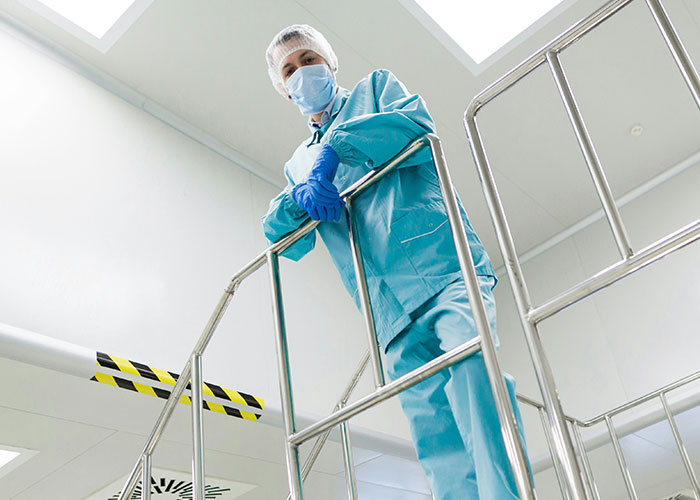 Healthcare worker in protective clothing on metal stairs, illustrating blue collar workers' scariest job site moments.