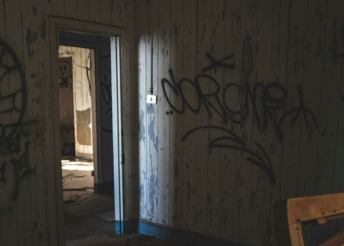 Interior of an abandoned job site with graffiti on peeling walls, depicting a scary moment shared by blue collar workers.